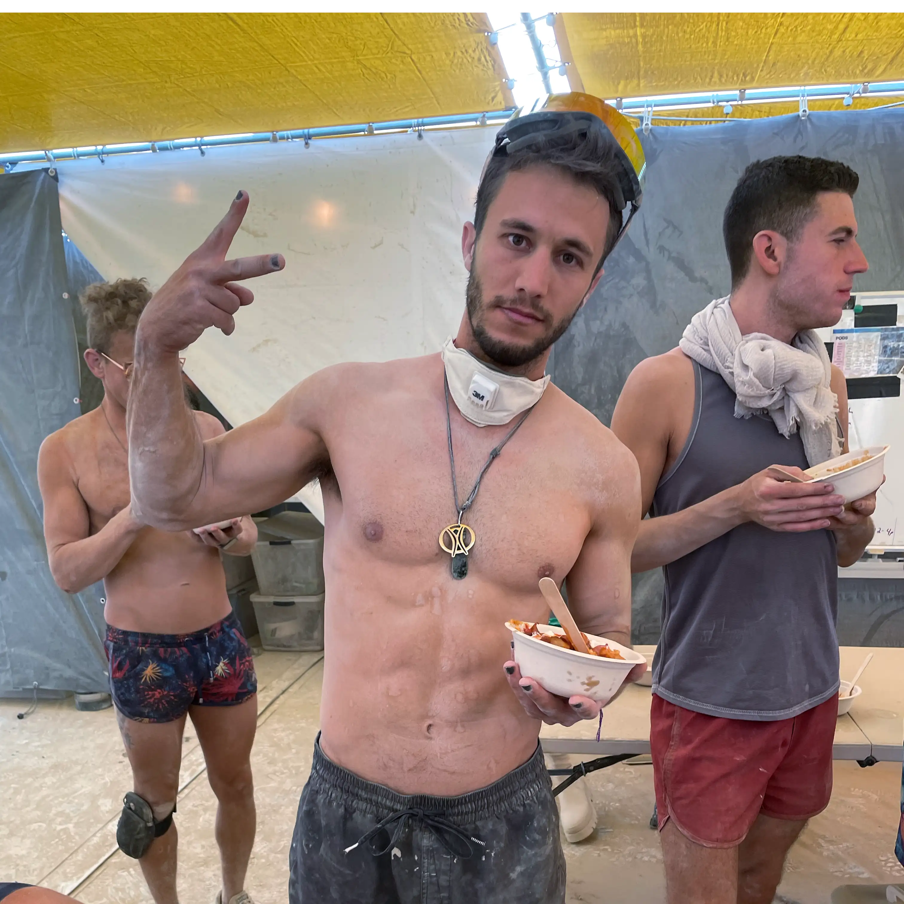 Three dusty, young, muscular men eating some kind of stew from bowls in the Future Turtles kitchen area.